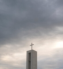 Christian cross on a roof with a dramatic background