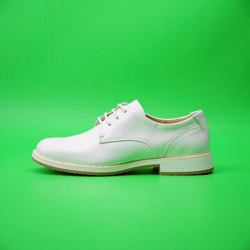 Blanco calzado con suela de cuero en fondo verde, calzado exterior, moda, calzado verde