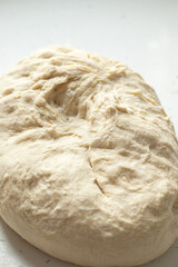 Homemade wheat flour dough for bread or pizza. Close-up. Selective focus.