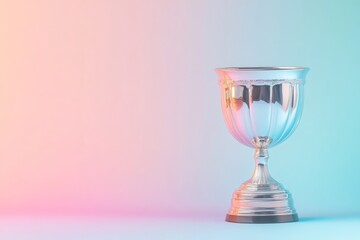 A sleek silver cup trophy stands elegantly against a smooth gradient background. The design emphasizes the trophy's craftsmanship, symbolizing achievement and excellence. With copy space for text