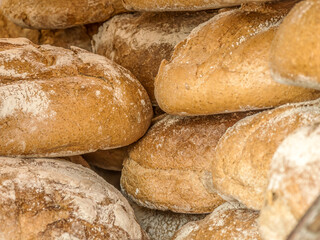 A close-up view of crusty, golden artisan bread loaves, emphasizing their rustic texture and homemade quality. This scene celebrates traditional baking and the authentic craftsmanship involved in