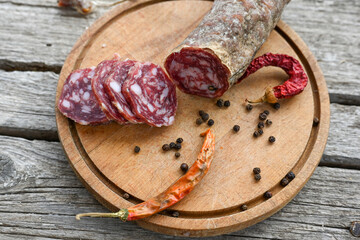 Air-dried typical  Italian salami from Tuscany served on a wooden board .  Autentic Tuscan Salami from San Gimignano, Siena 