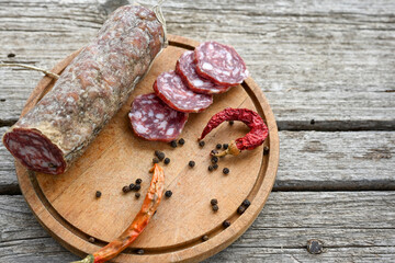 Air-dried typical  Italian salami from Tuscany served on a wooden board .  Autentic Tuscan Salami from San Gimignano, Siena 