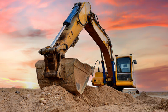 Excavator on earthmoving at construction site. Backhoe dig pit foundation.  Construction machinery and equipment on groundwork. Road work