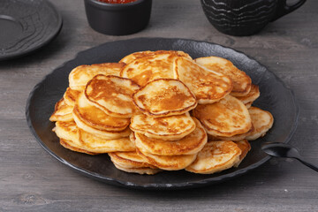 Delicious stack of golden pancakes served with caviar on a rustic table