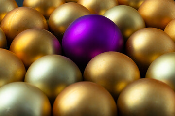 varias esferas amarillas al centro sobresale una esfera diferente, mas grande de color violeta