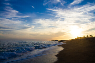 beautiful and colorful sunset, warm light and many clouds, sea waves on the sea coast
