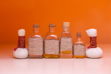 beautiful bottles with massage oil on orange background
