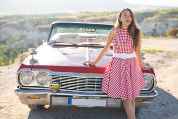 beautiful girl in a retro dress at sunrise happy posing on the background of the mountain landscape...