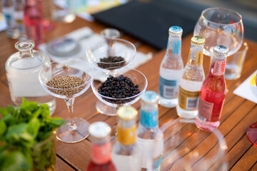 many different ingredients on the bartender's table for making alcoholic cocktails