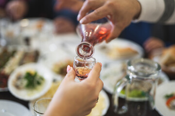 a waiter in a restaurant pours alcohol into a glass at the table