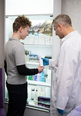 Obraz premium A man doctor talks to his boy patient and advises him on medicine