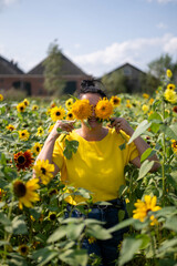 Meisja yellow blouse and sunflower field. Beautiful sunny day.