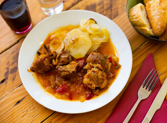 Restaurants guests will have hearty lunch - Carilladas estofadas pork stewed with vegetables, potato, carrots and peppers in spicy gravy, served with slices of bran baguette