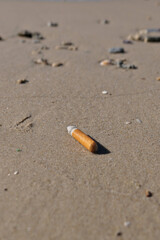 Cigarette butt on the beach. Conceptual image of quitting smoking