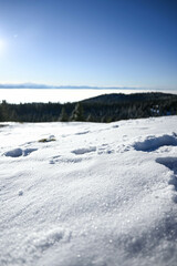 Bokeh shot of snow steps in the alpine mountains over a sea of clouds with Mont Blanc in the distance