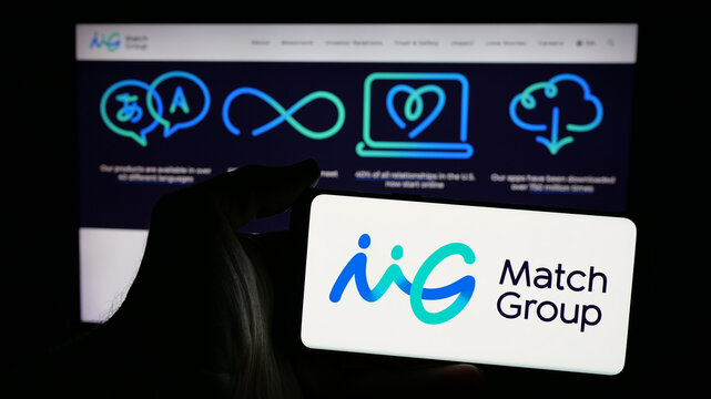 Stuttgart, Germany - 01-20-2025: Person holding mobile phone with logo of American online dating company Match Group Inc. on screen in front of web page. Focus on phone display.