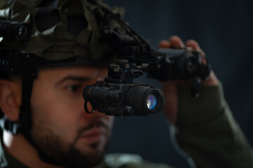 A special forces member using night vision monocular. Close up.