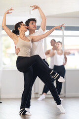 Obraz premium Young guy and adult woman dancers rehearsing pair ballet in studio