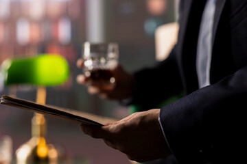Secret service manager presenting important case files details over a glass of whiskey, meeting with agent to share insight and collaborate on national safety mission. Intelligence agency. Close up.