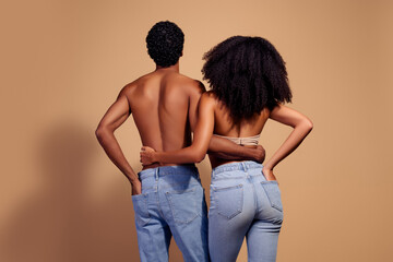 Young couple embracing in studio with beige background showcasing love and connection in stylish and intimate setting.
