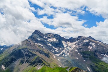Fototapeta premium This stunning landscape in Kaprun, Austria showcases majestic mountains with snow-capped peaks and lush green fields, inviting viewers to immerse themselves in the beauty of nature.