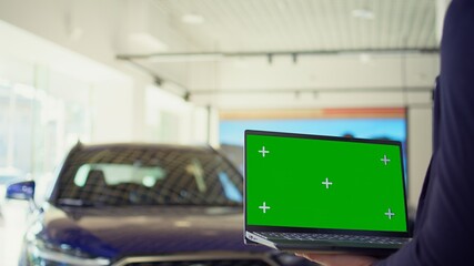 Salesperson using isolated screen laptop to present car addons options to clients, persuading them to buy. Showroom agent offers extended warranty to customers, holding chroma key notebook, camera B