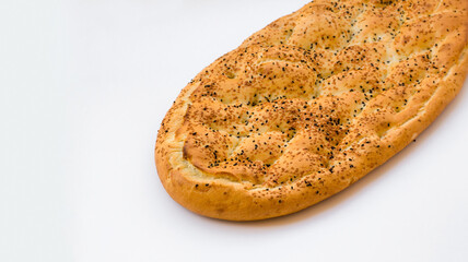 Traditional Turkish Ramadan Bread baked with sesame seeds,black cumin and eggs on white surface.Top and half view