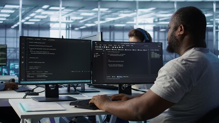 Admin in server hub tasked with protecting valuable data against hacking attack on computers. African american worker safeguarding data center against unauthorized access and vulnerabilities, camera B