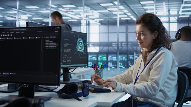 Joyful technician working in high tech workspace providing computing resources for different workloads. Relaxed woman tasked with monitoring data center supercomputers, camera B