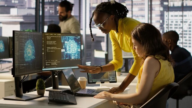 Admin and coworker conducting experiments and tests to optimize AI machine learning models for performance and accuracy. Team of IT experts in office analyzing artificial intelligence data, camera A