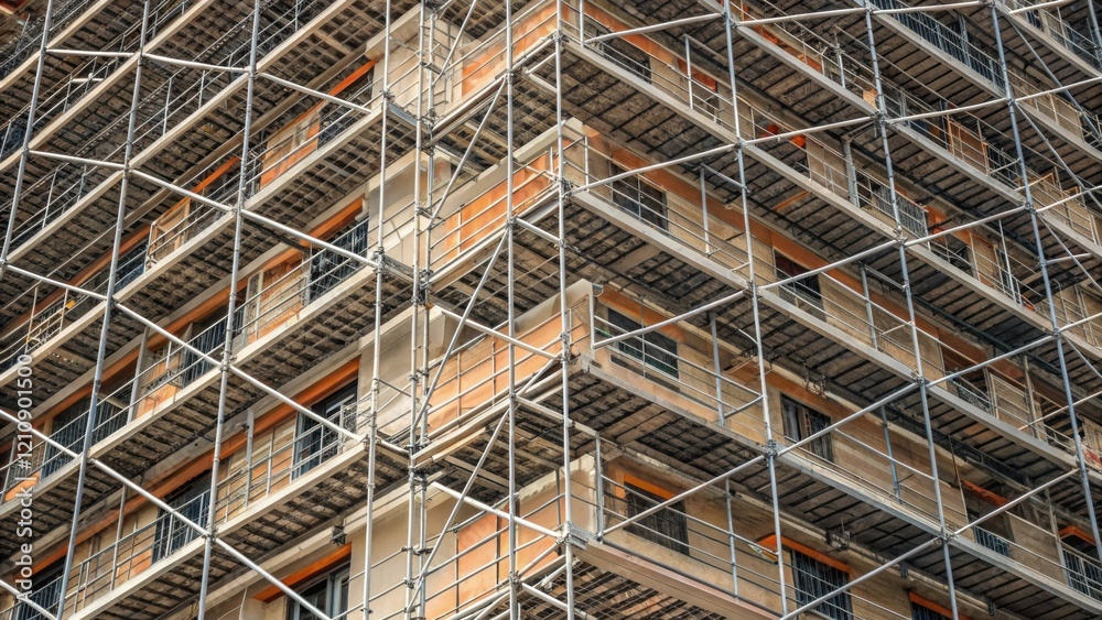 Aufkleber A medium closeup image revealing the intricate patterns of scaffolding surrounding a multistory building highlighting the geometric alignment of platforms and safety nets.