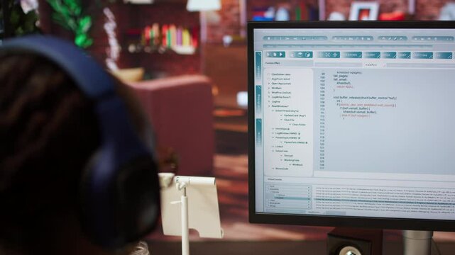 Engineer in home office looking at UI on computer monitor, typing and executing programming code. Close up of person using coding application to write and test code in modern apartment, camera A