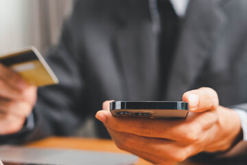 Close up Male hands holding credit card and smartphone, man paying online, credit card shopping, using banking service, entering information, shopping, ordering in internet store, doing secure payment