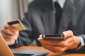 Close up Male hands holding credit card and smartphone, man paying online, credit card shopping, using banking service, entering information, shopping, ordering in internet store, doing secure payment