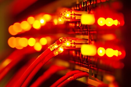 Red network cables glowing in server rack.