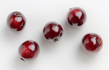 Five glossy red currants on white background.