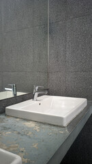 A spotless and modern wash basin with a sleek design, equipped with a clean faucet and mirror. Ideal for public or private spaces, ensuring hygiene and convenience for washing hands or face.