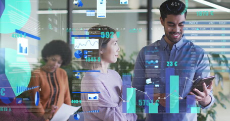 Image of charts processing data over happy diverse colleagues with tablet at casual office