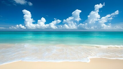 Golden sand dunes meeting crystal-clear turquoise ocean waves under a bright blue sky.