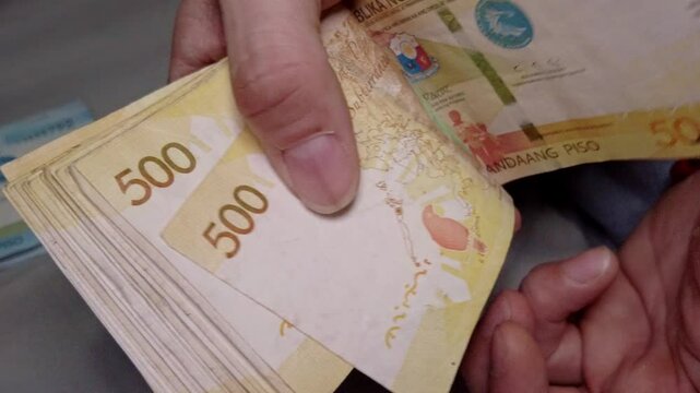 Detailed View of Hands Counting Money - Philippine 500 Peso Cash