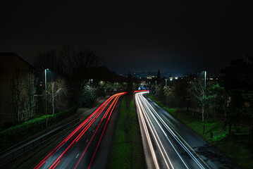 Long exposure view of cars light trails at night. Evening city traffic on a highway. Norwich,...