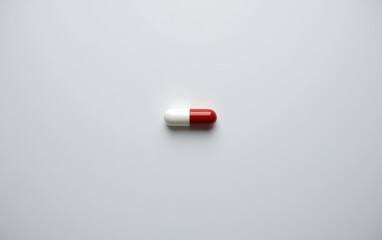 A single  capsule pill resting on a clean white surface, casting a subtle shadow.
