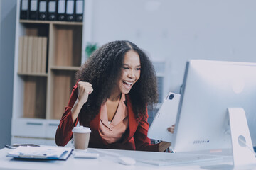 Excited african American woman sit at desk feel euphoric win online lottery, happy black woman...
