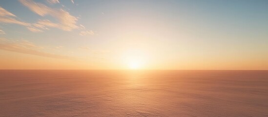 Fototapeta premium A peaceful sunrise or sunset sky with a smooth gradient from light blue to golden yellow, wispy clouds, and a soft glowing sun casting a serene light over the horizon.