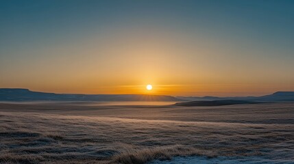 Obraz premium A serene sky at dawn or dusk featuring a smooth blue-to-golden-yellow gradient, wispy clouds, and a soft glowing sun with an ethereal halo near the horizon.