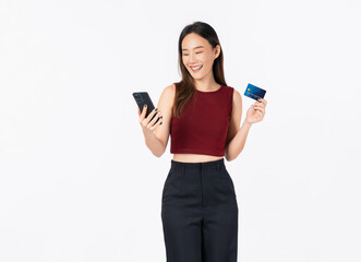 Naklejka premium Beautiful Asian woman holding credit card and using smartphone on white background.
