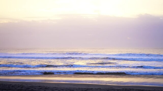 Vibrant yellow pink sunset sunrise peaceful shoreline beach waves crashing Pacific Ocean California Big Sur San Simeon San Luis Obispo cloud layer golden hour coastal drive highway 1 slowly zoom in
