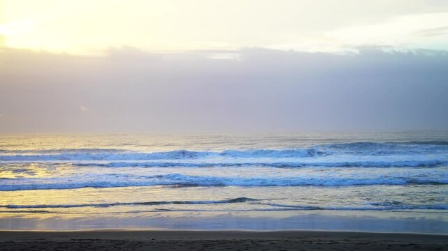 Vibrant sunset sunrise peaceful shoreline beach waves crashing Pacific Ocean California Big Sur San Simeon San Luis Obispo cloud layer golden hour coastal drive highway 1 slowly zoom in
