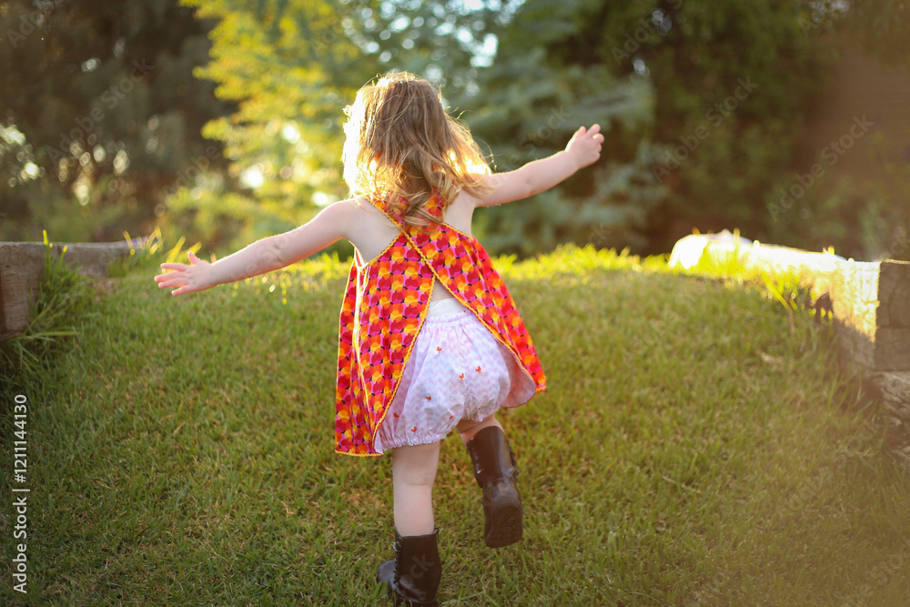 Wall mural Little girl wearing red dress exploring lush green garden